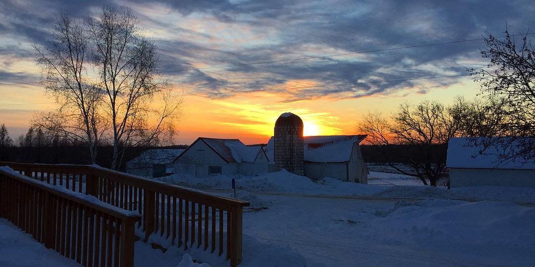 An orange sunset over a snow-covered landscape