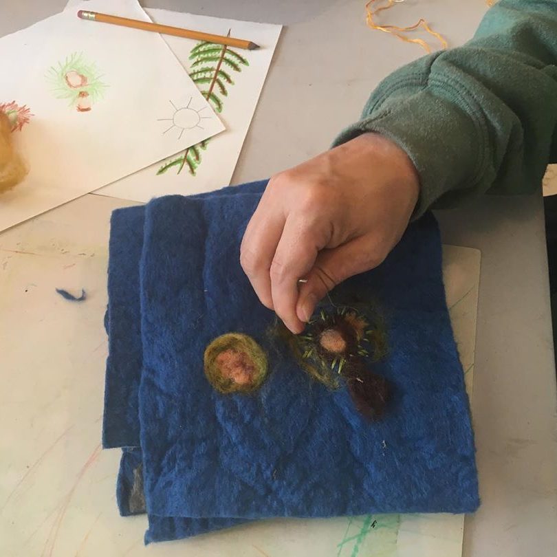 A person works on an embroidery project