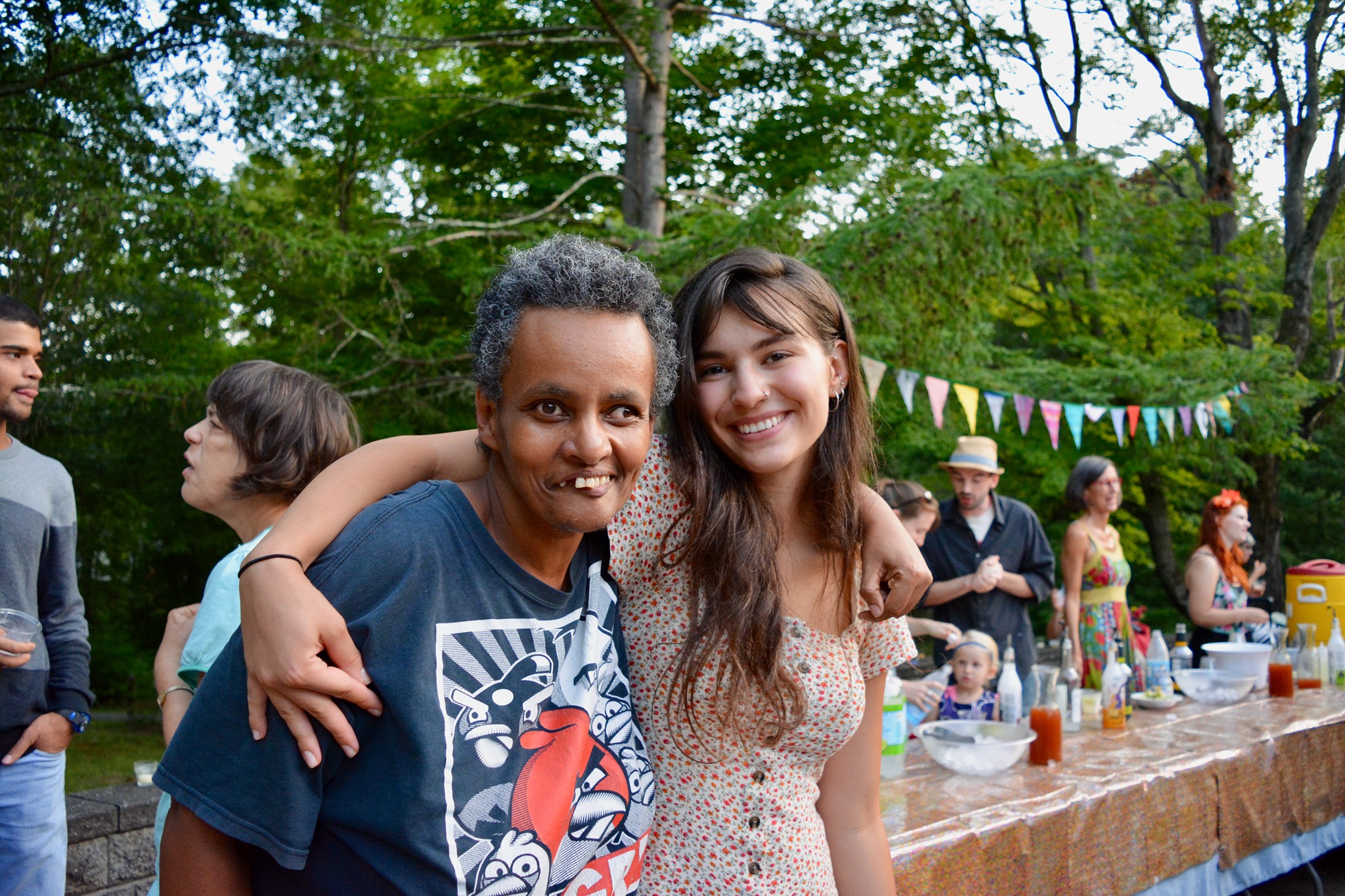 Two people hugging at an outdoor party