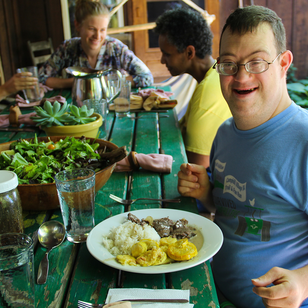 A man smiles at a dinner table