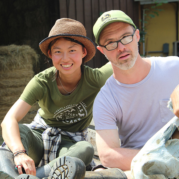 A volunteer and a resident on a farm smiling