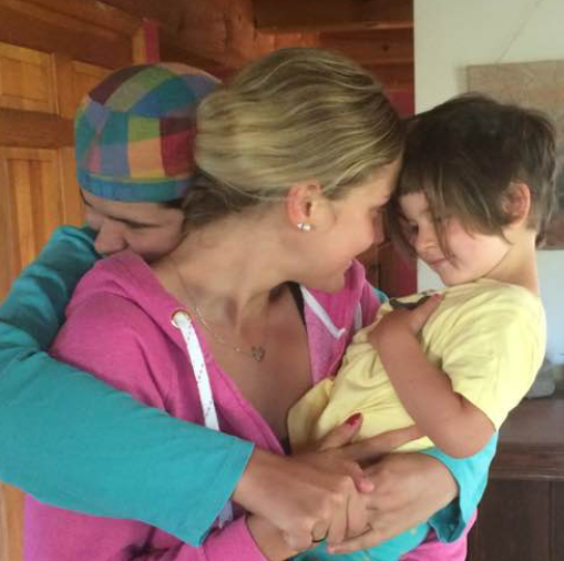 Two adults and a child hugging each other