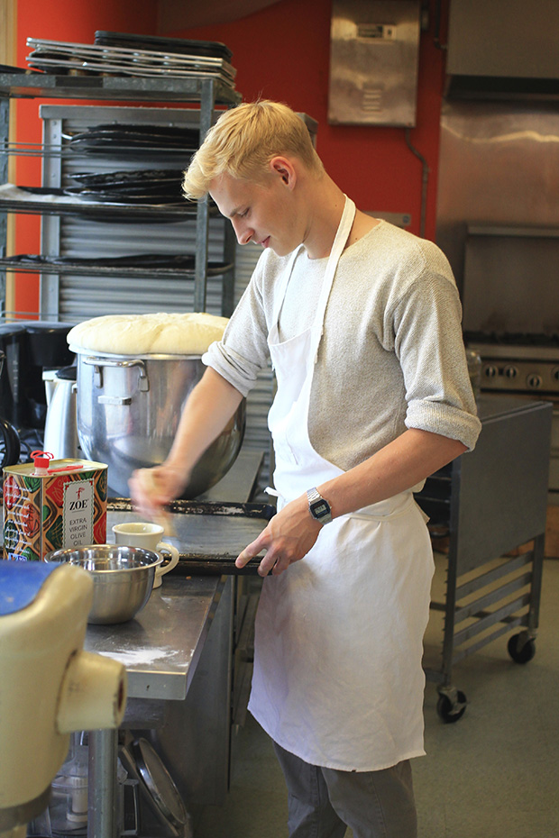 A young man bakes bread in a cheerful red kitchen