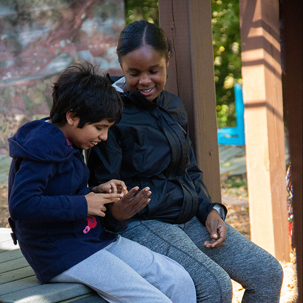 Two people sitting outside holding hands