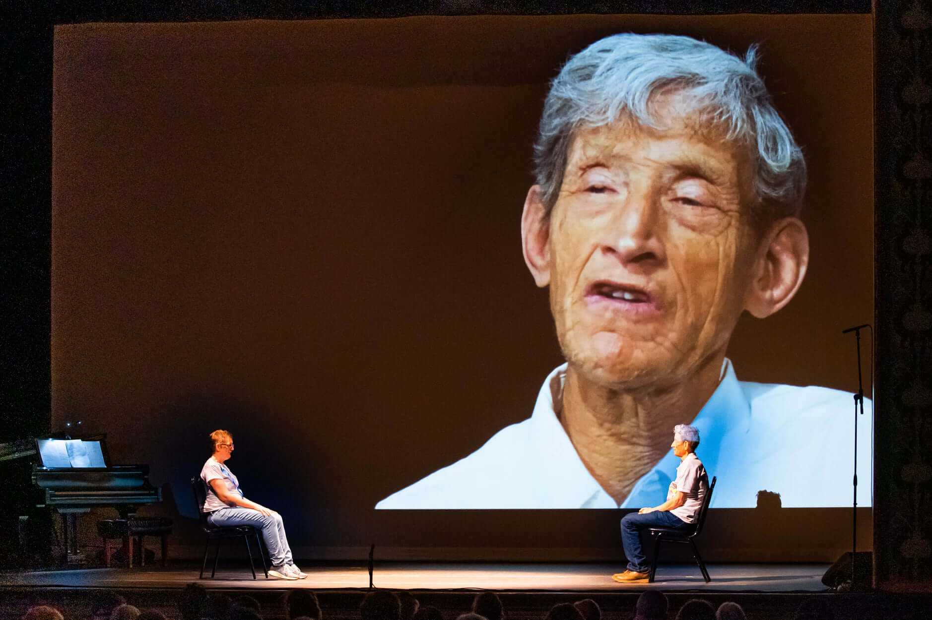 Elias is projected large onto a screen behind the stage during a Camphill Hudson performance