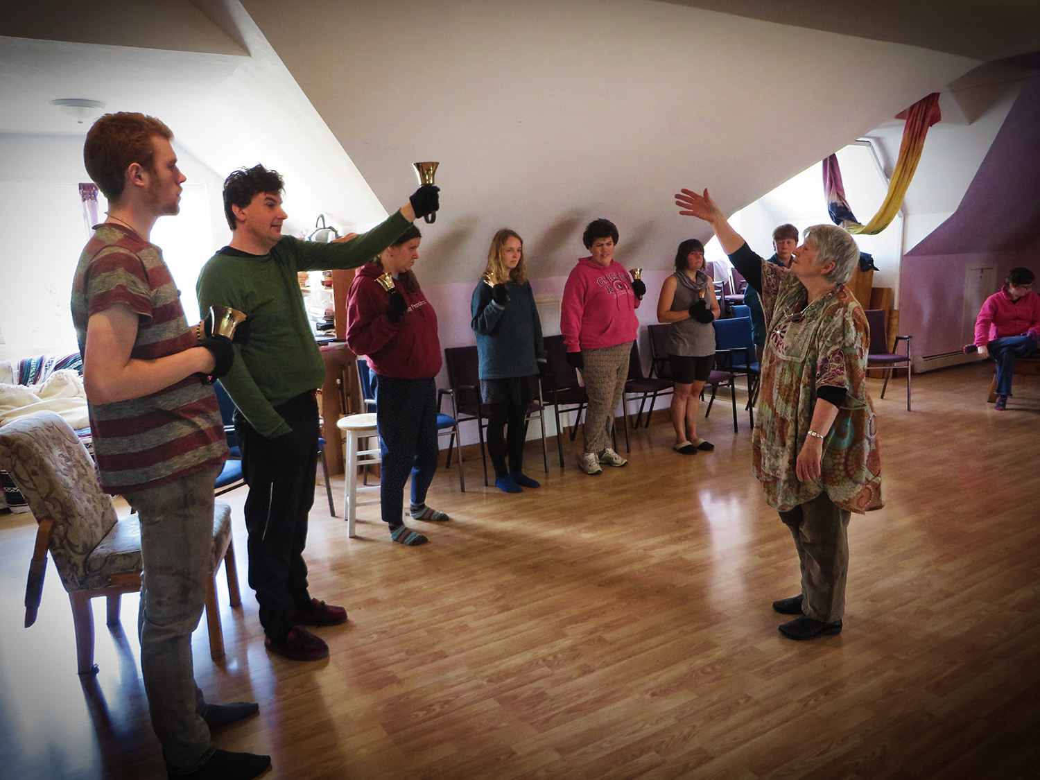 A bell choir rehearsing in a room with a slanted roof
