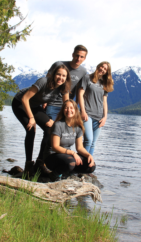 A group of people standing next to a lake