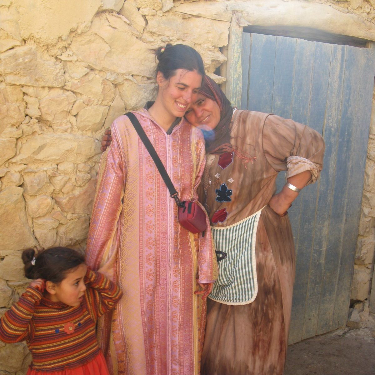 Three people hold hands and smile