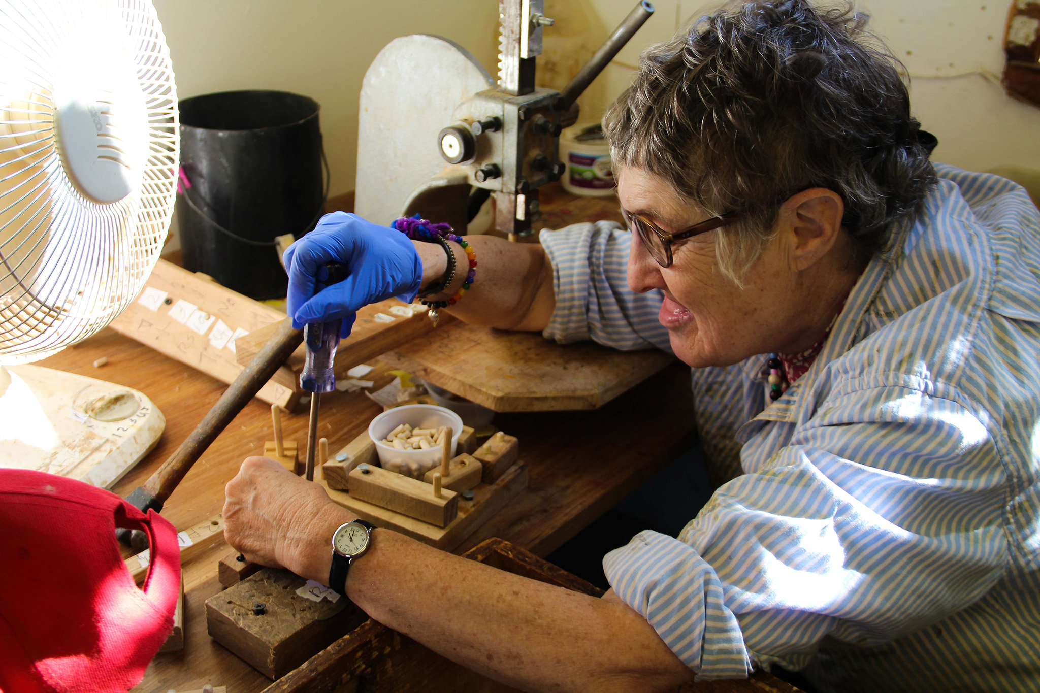 A person carefully uses a screwdriver on a wooden project