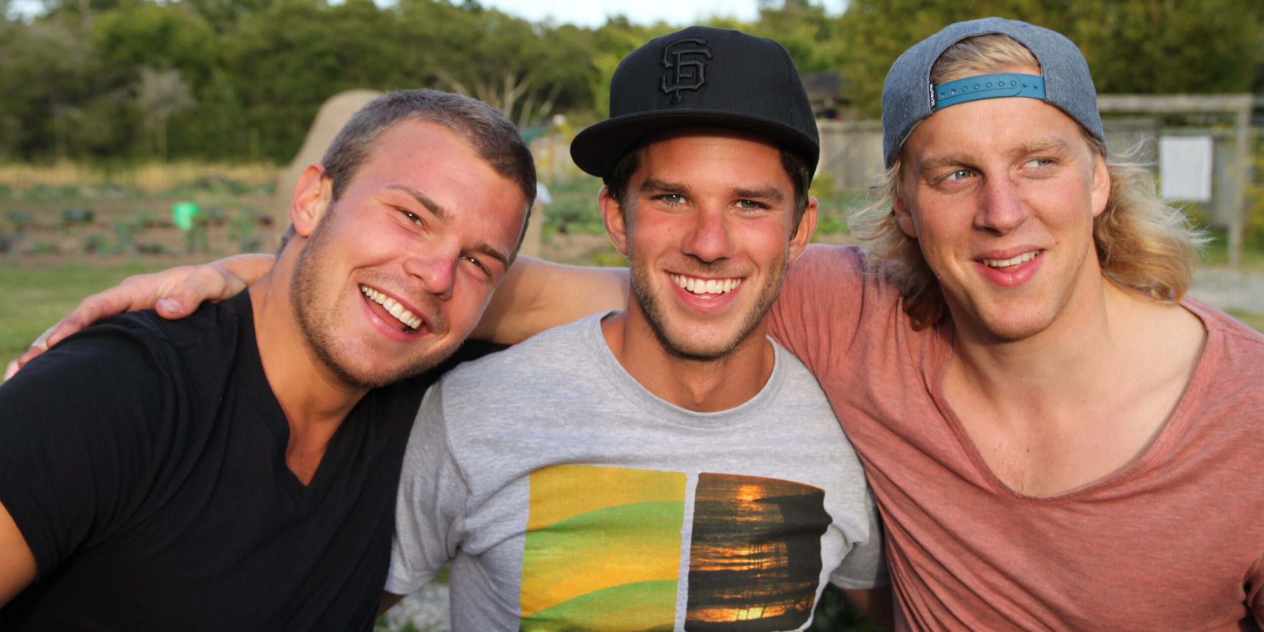 Three young men hugging each other and smiling