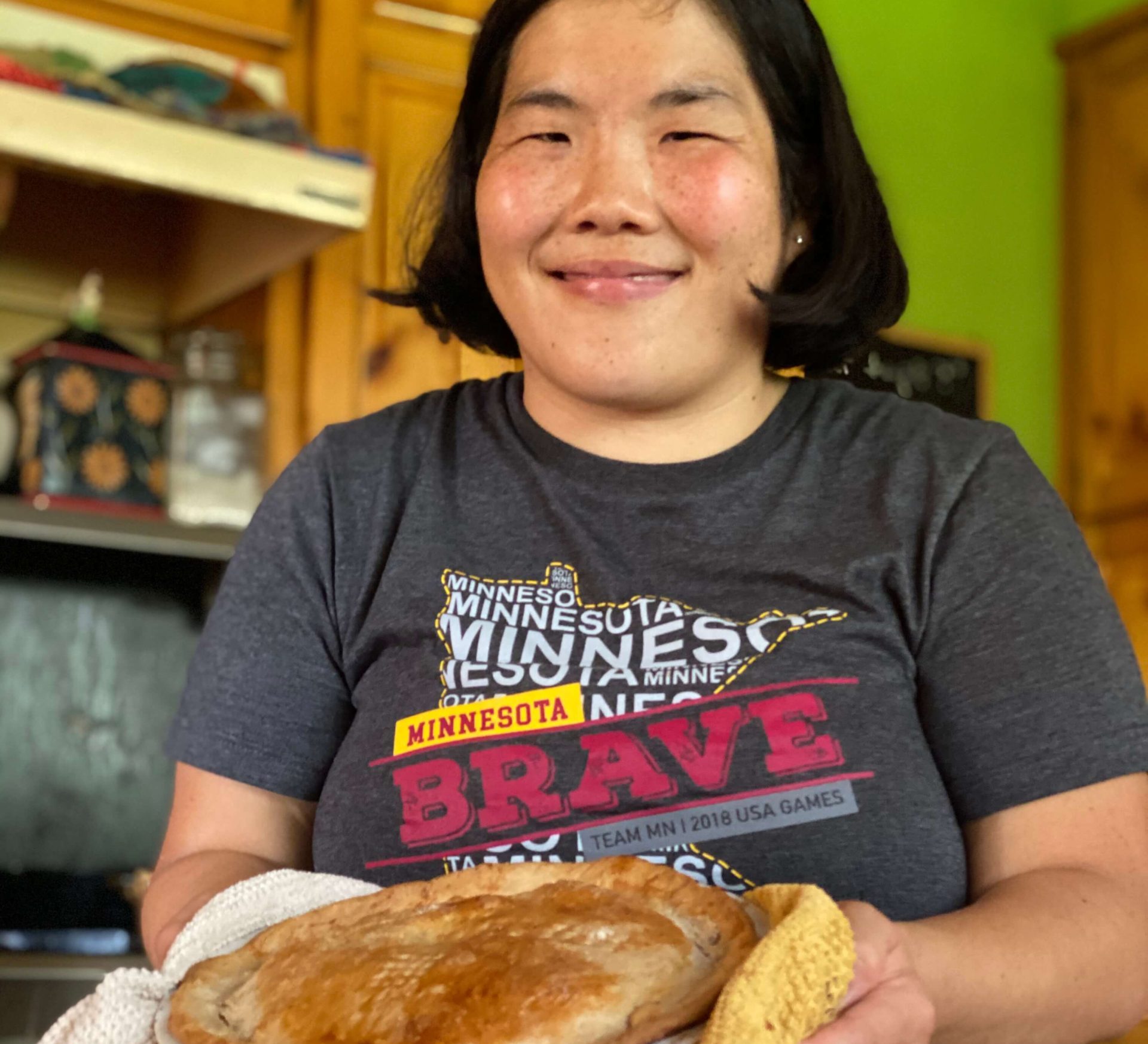 Photograph of Nae Nae by Nicolo. Nae Nae is smiling and holding a pie fresh out of the oven.