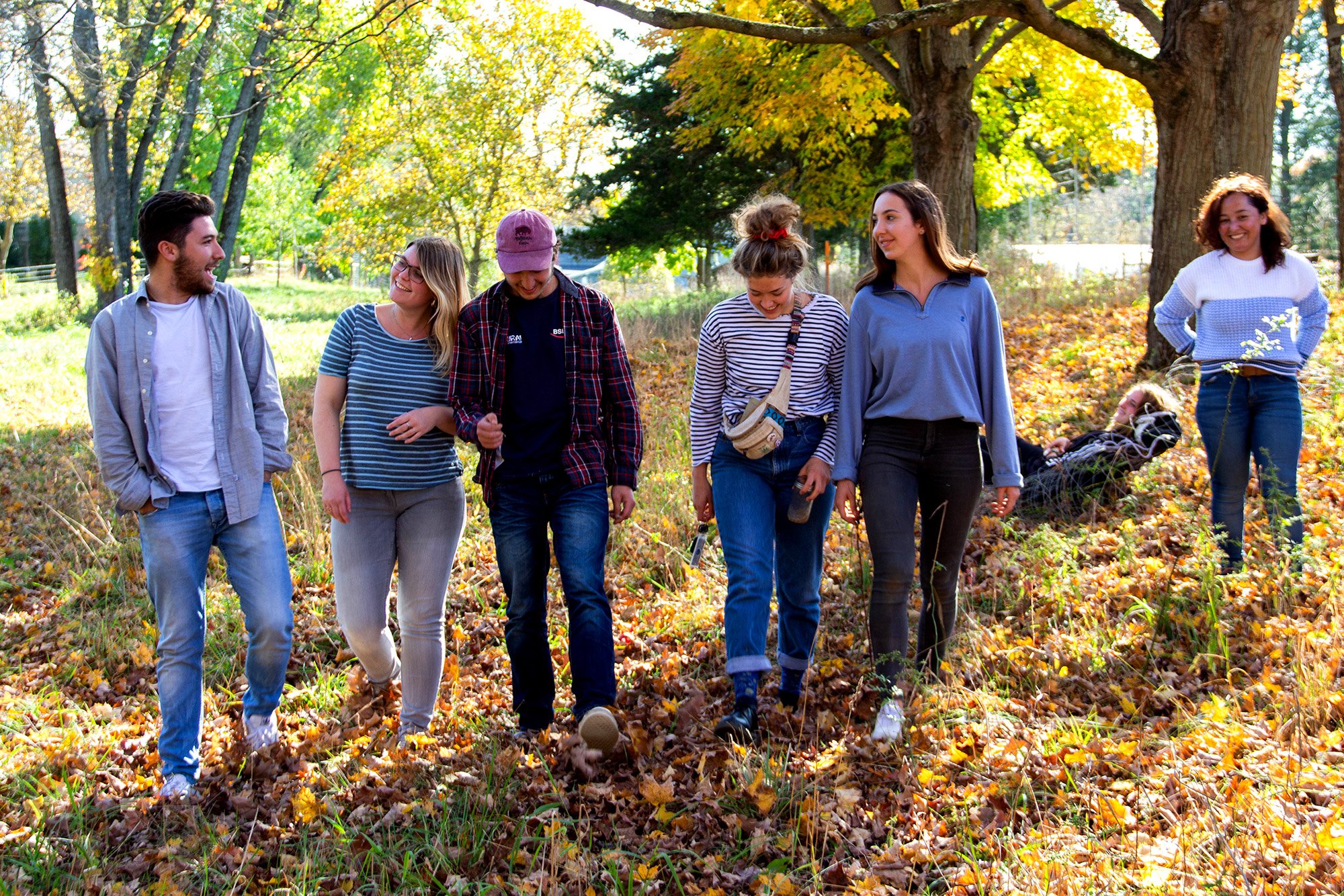 Volunteers smiling as they walk through autumn leaves outside