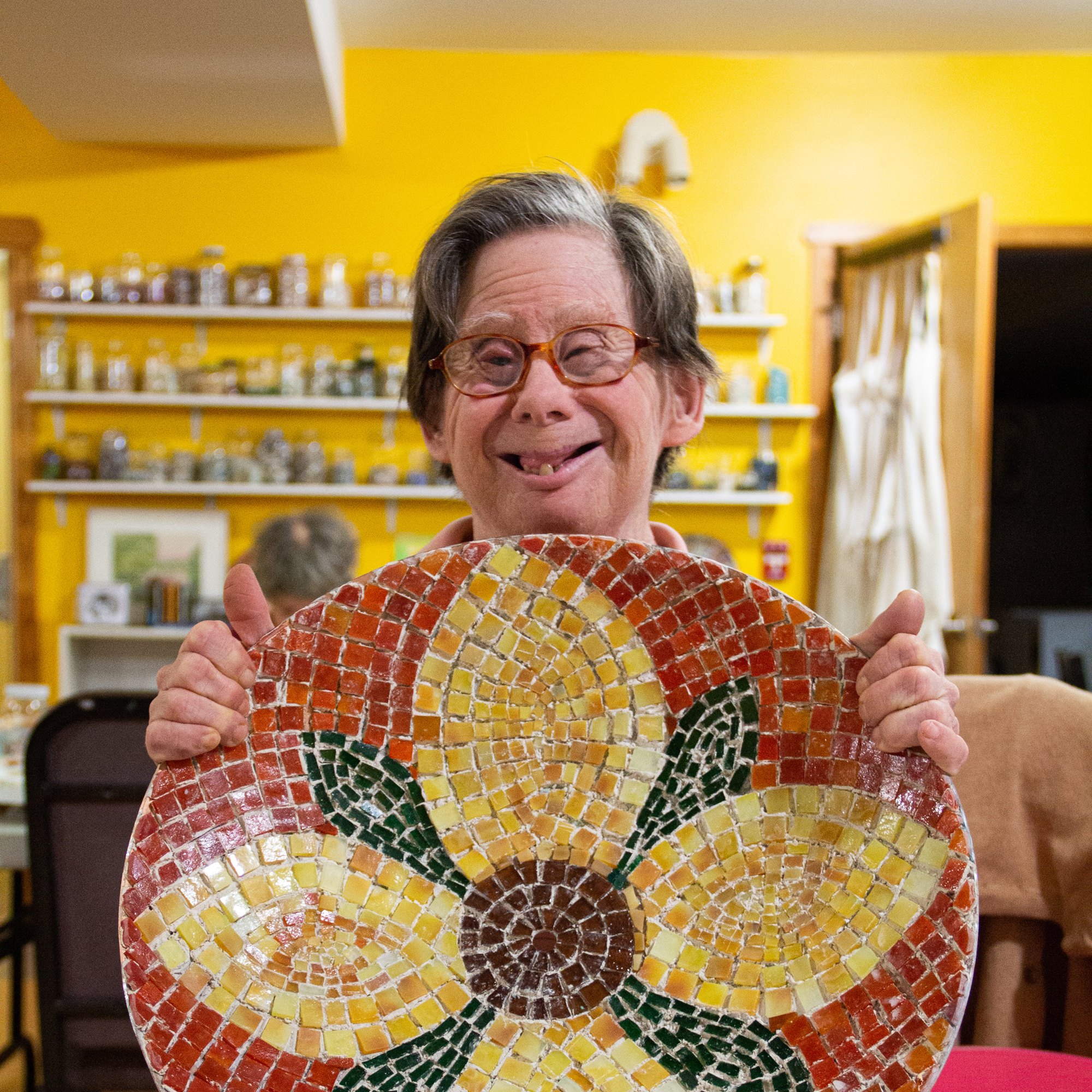 A woman holds up her floral mosaic