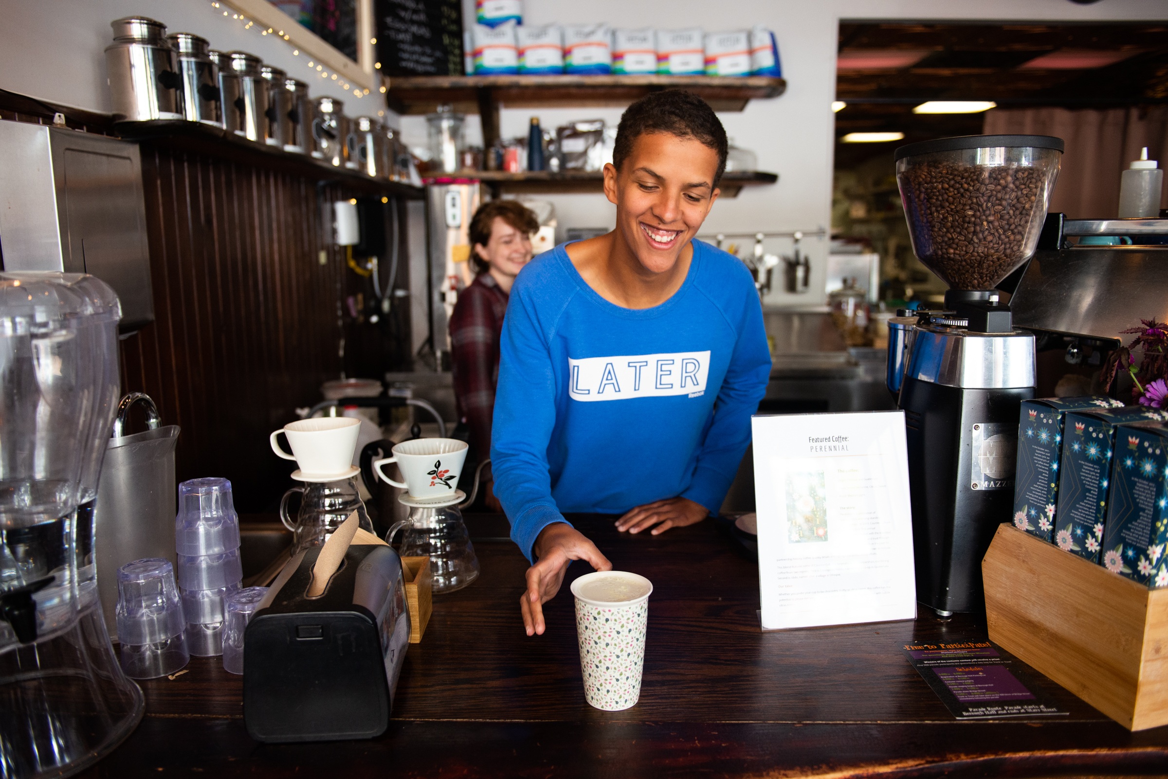 A barista serves coffee with a smile at Camphill Soltane