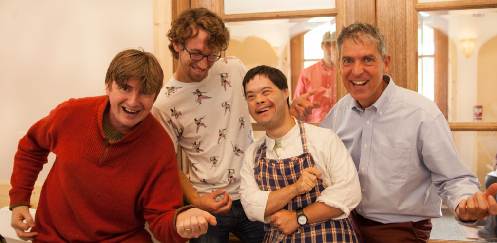 Four people of all ages laughing and posing together